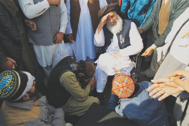 A supporter prays at the feet of Rizvi